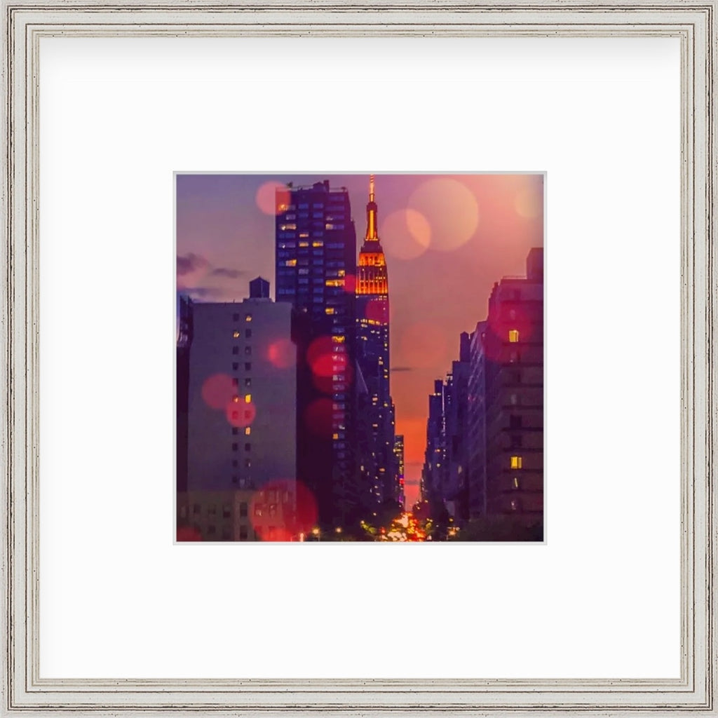 Framed Picture Of A City Scape In Front Of An Orange Sunset