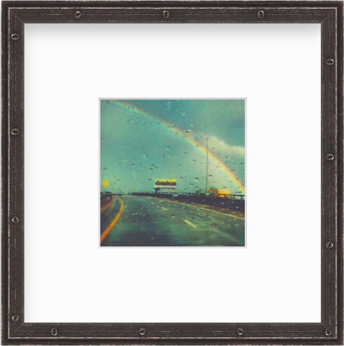 Framed Picture Of A Rainbow Above A Road Through Rainy Glass
